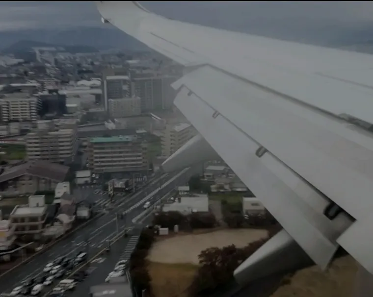 最大フラップで街中を降下する飛行機の主翼です